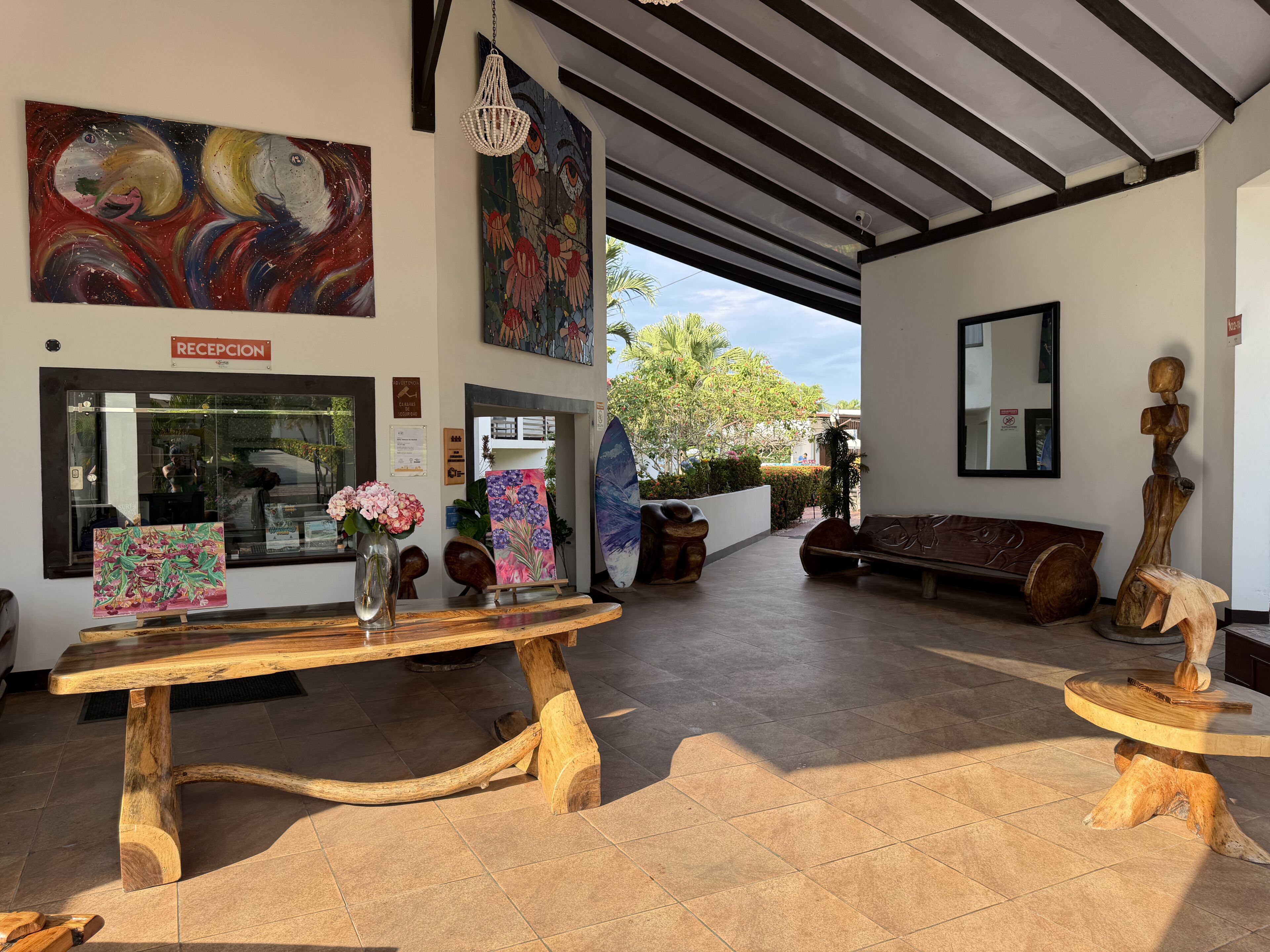 A reception area with a wooden table, a vase with flowers, and artwork on the walls.