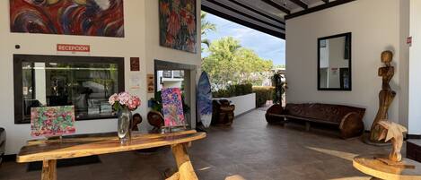 A reception area with a wooden table, a vase with flowers, and artwork on the walls.