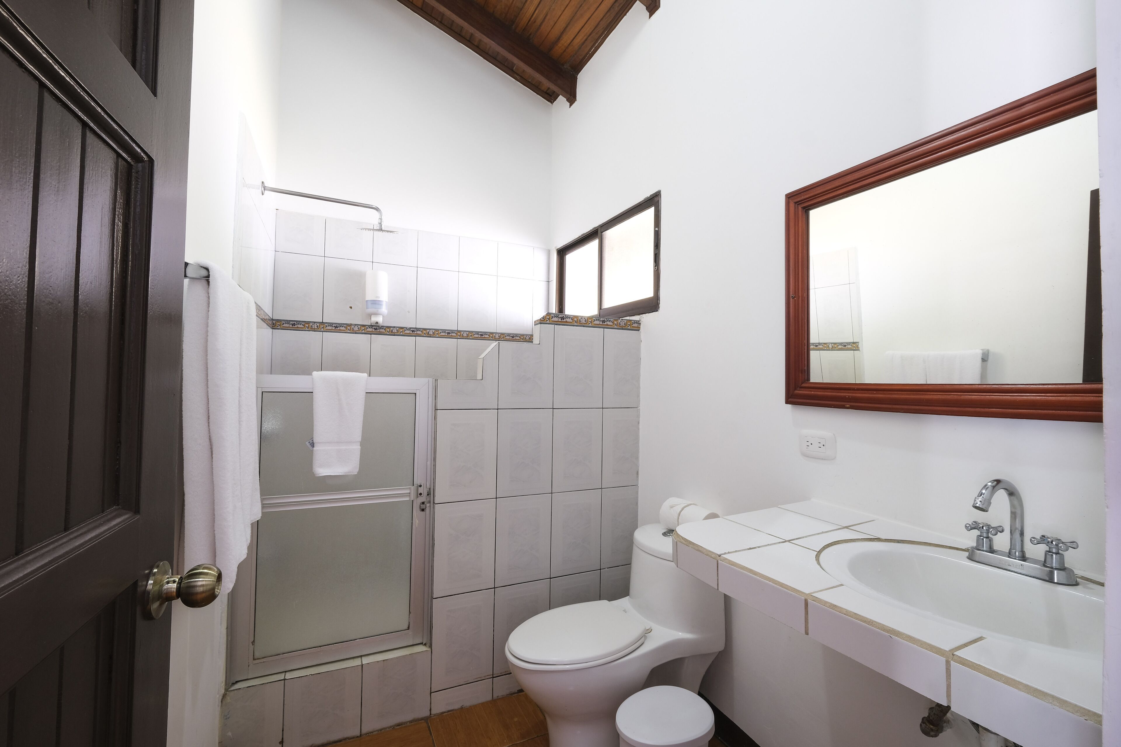 A bathroom with a toilet, sink, and shower.
