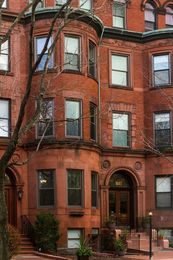 Stunning corner building with a black door and steps leading up to a charming entrance.