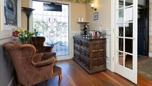Una habitación con un armario de madera, un sillón marrón y una ventana con vistas.