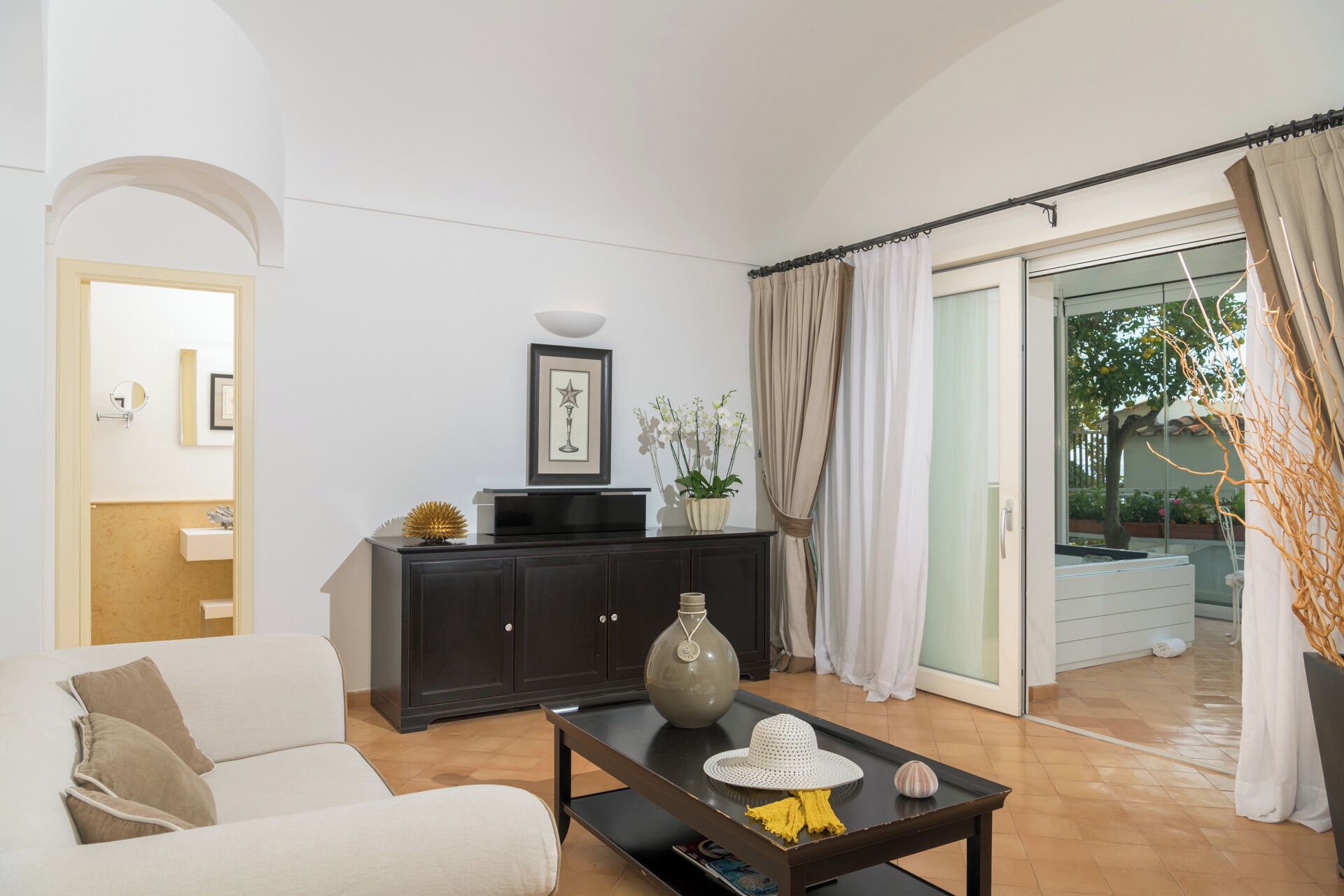 A living room with a sofa, a coffee table, a cabinet, and a door leading to a balcony.