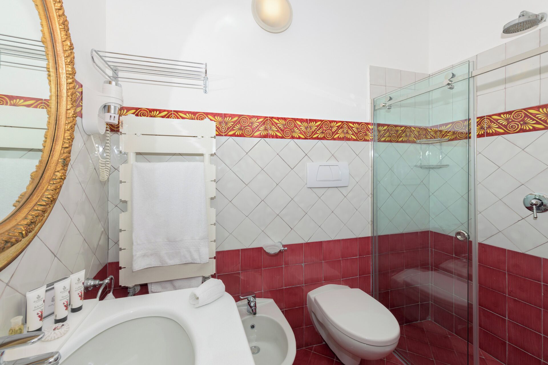A bathroom with a bathtub, toilet, and glass shower enclosure.