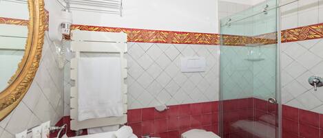 A bathroom with a bathtub, toilet, and glass shower enclosure.
