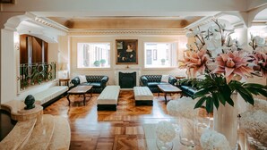 A spacious lobby with a fireplace, leather sofas, and a large window with a view. - River Palace Hotel (Rome)