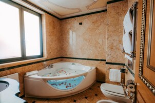 Et badeværelse med et fristående badekar, toilet og håndvask.