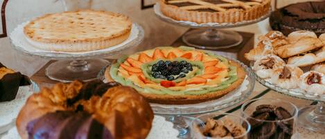 Een tafel met diverse desserts, zoals taarten, gebak en patisserie.