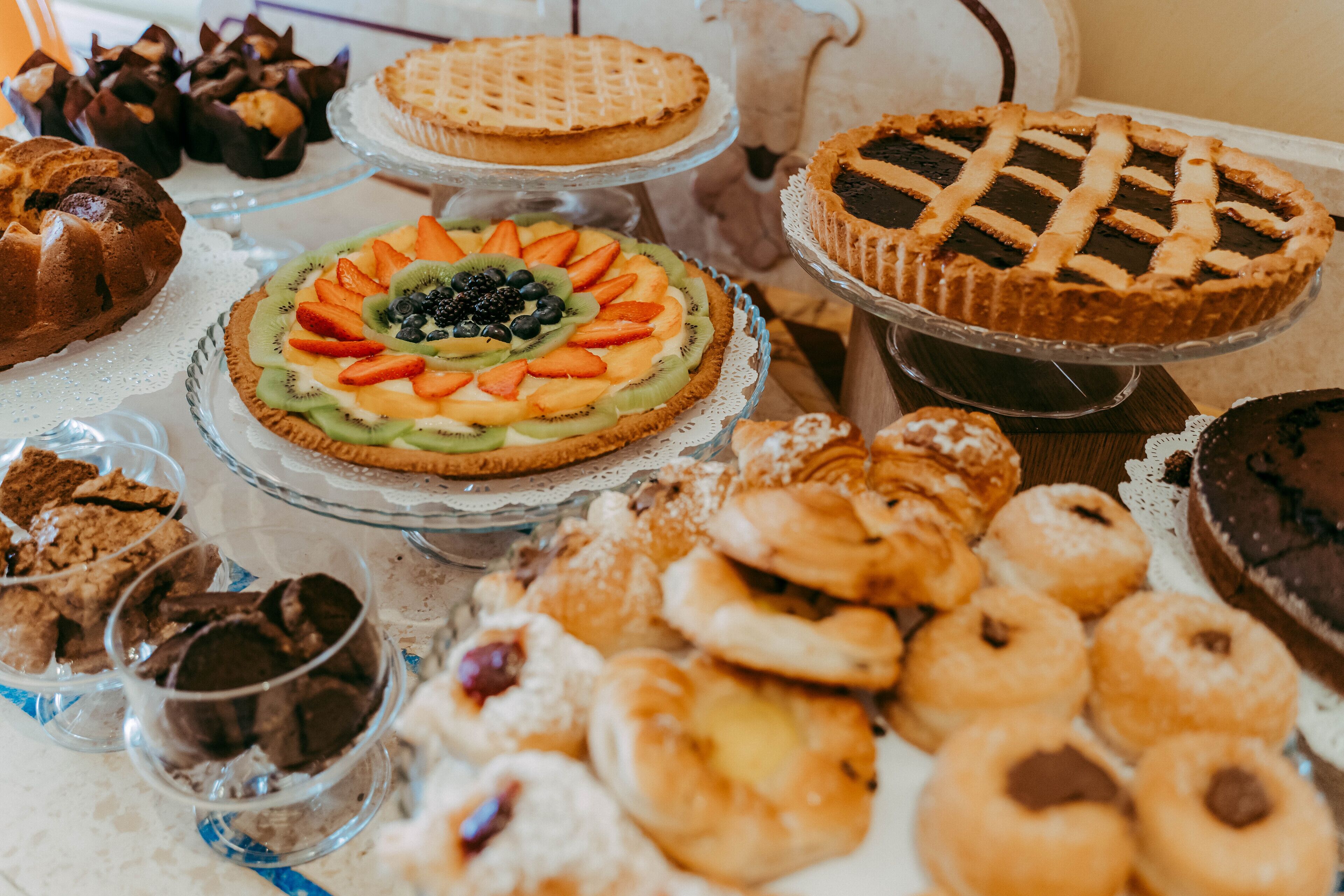A variety of desserts on a table, including pies, cakes, and pastries.