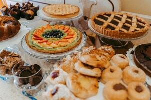 A variety of desserts on a table, including pies, cakes, and pastries.