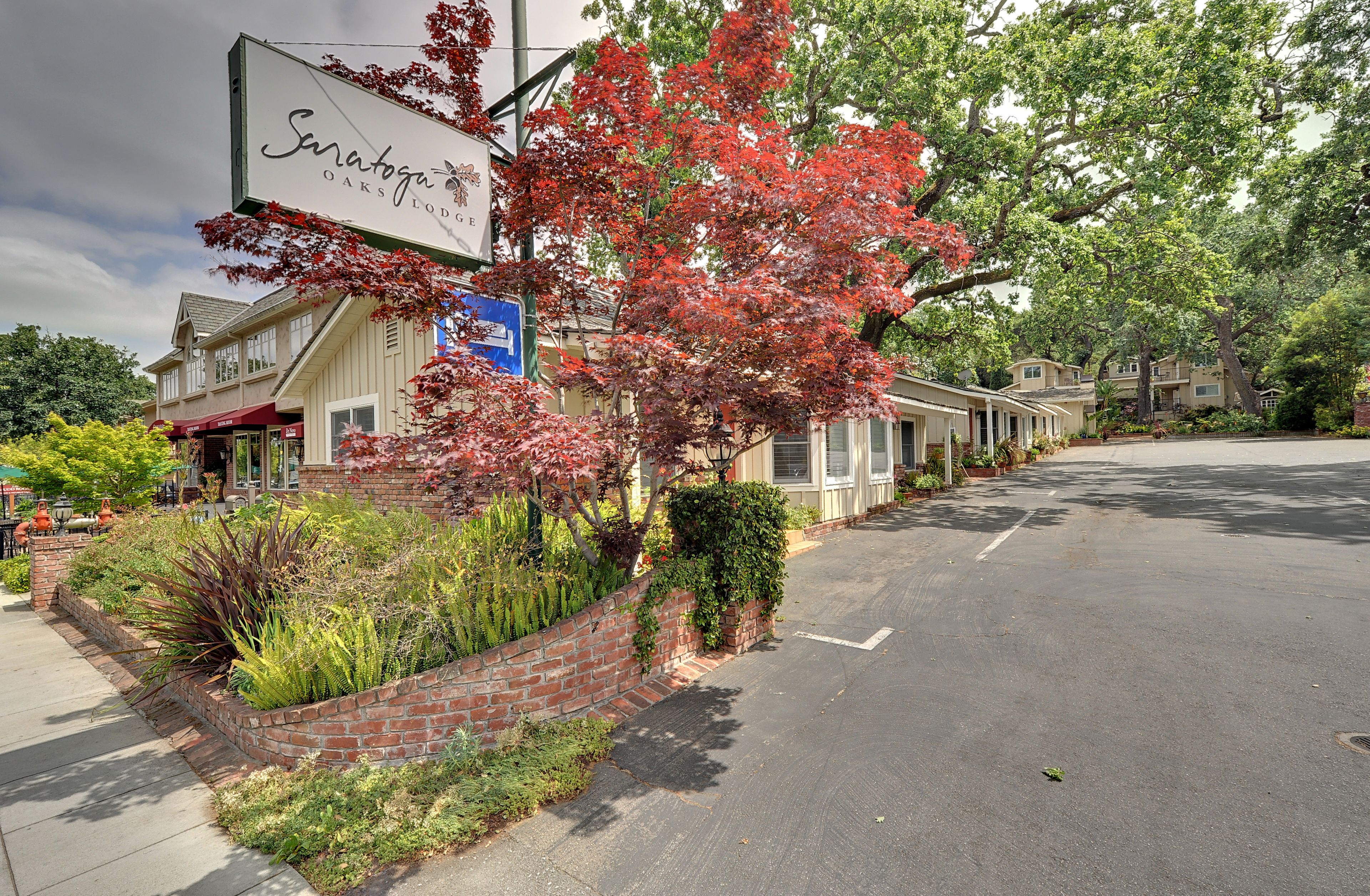 Une vue de rue avec un bâtiment portant l’inscription « Samatoga Oaks Lodge ».