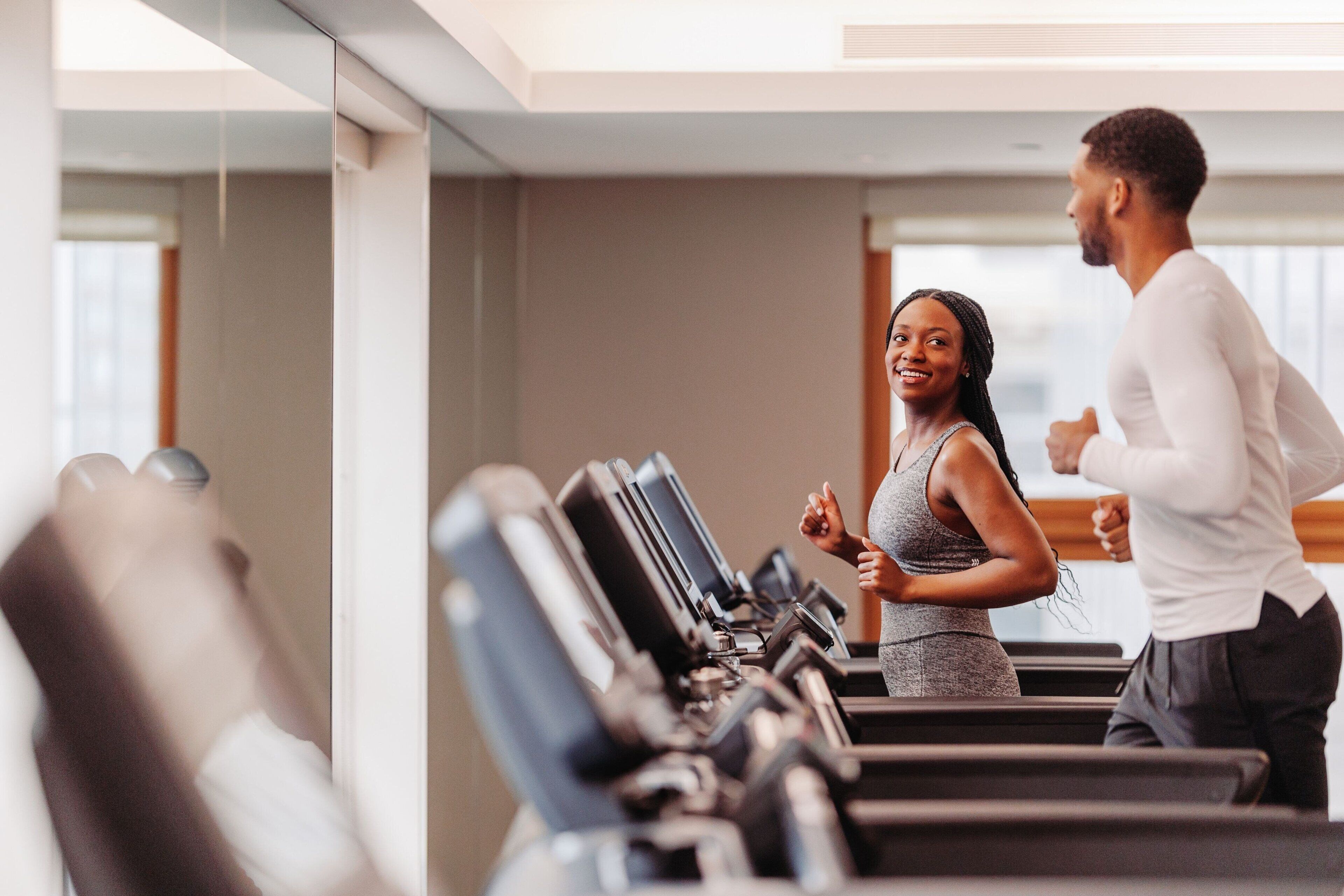 Ein Fitnessraum mit Laufbändern und einer trainierenden Person.