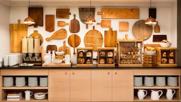 Una cocina con tablas de cortar de madera, una máquina de café y platos y cuencos ordenados.