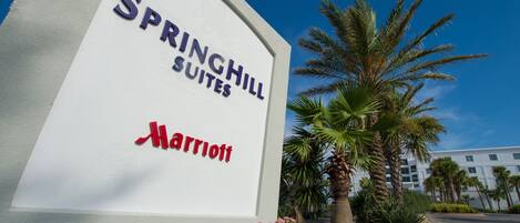 A sign for Springhill Suites Marriott with a clear view of the hotel building in the background.