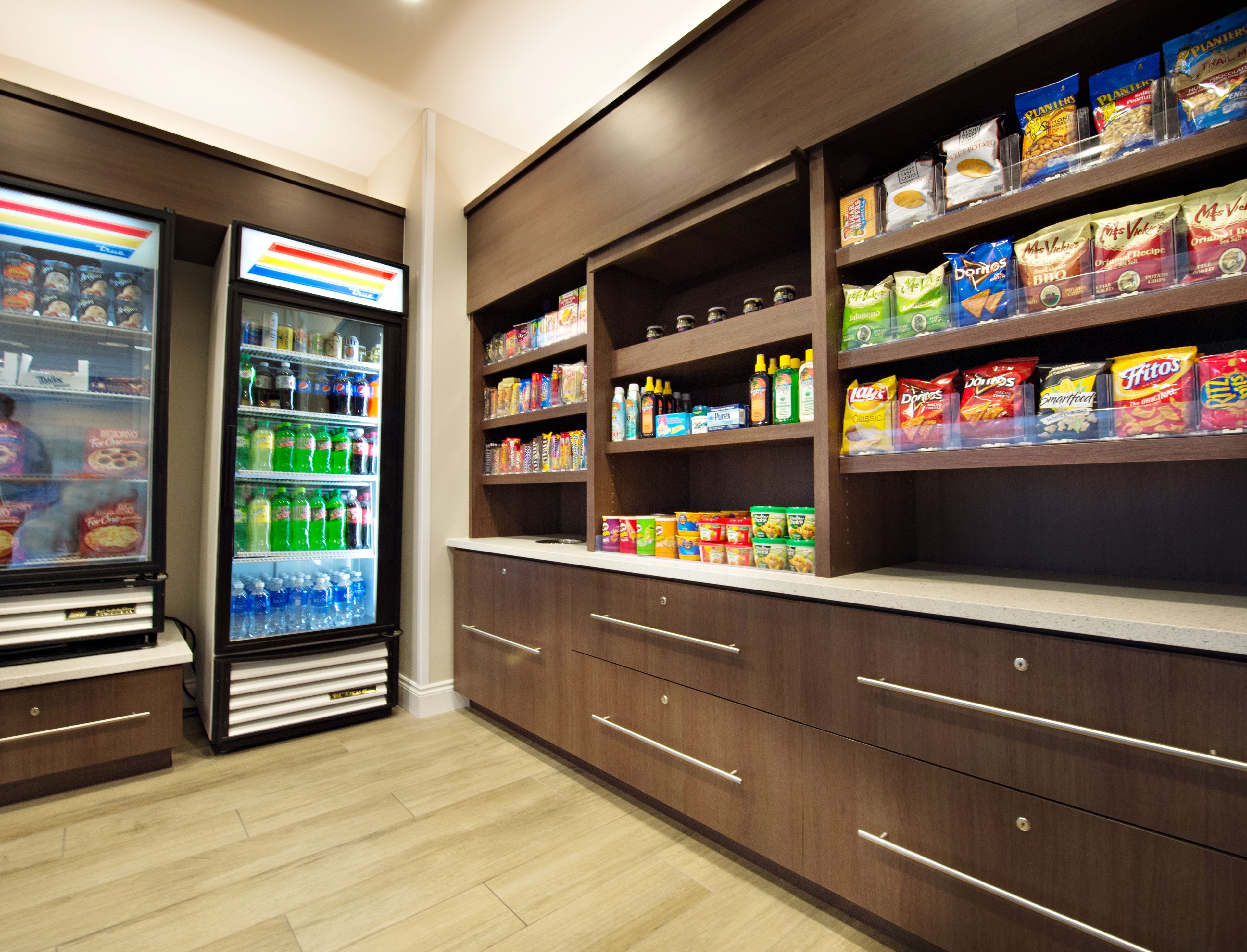 A snack and beverage section with refrigerated drinks and shelves stocked with snacks and condiments.
