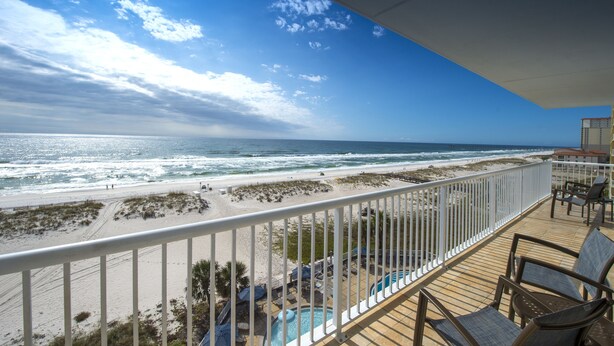 A balcony with a view of the beach and ocean, a pool, and outdoor seating. - SpringHill Suites Pensacola Beach (Pensacola Beach)
