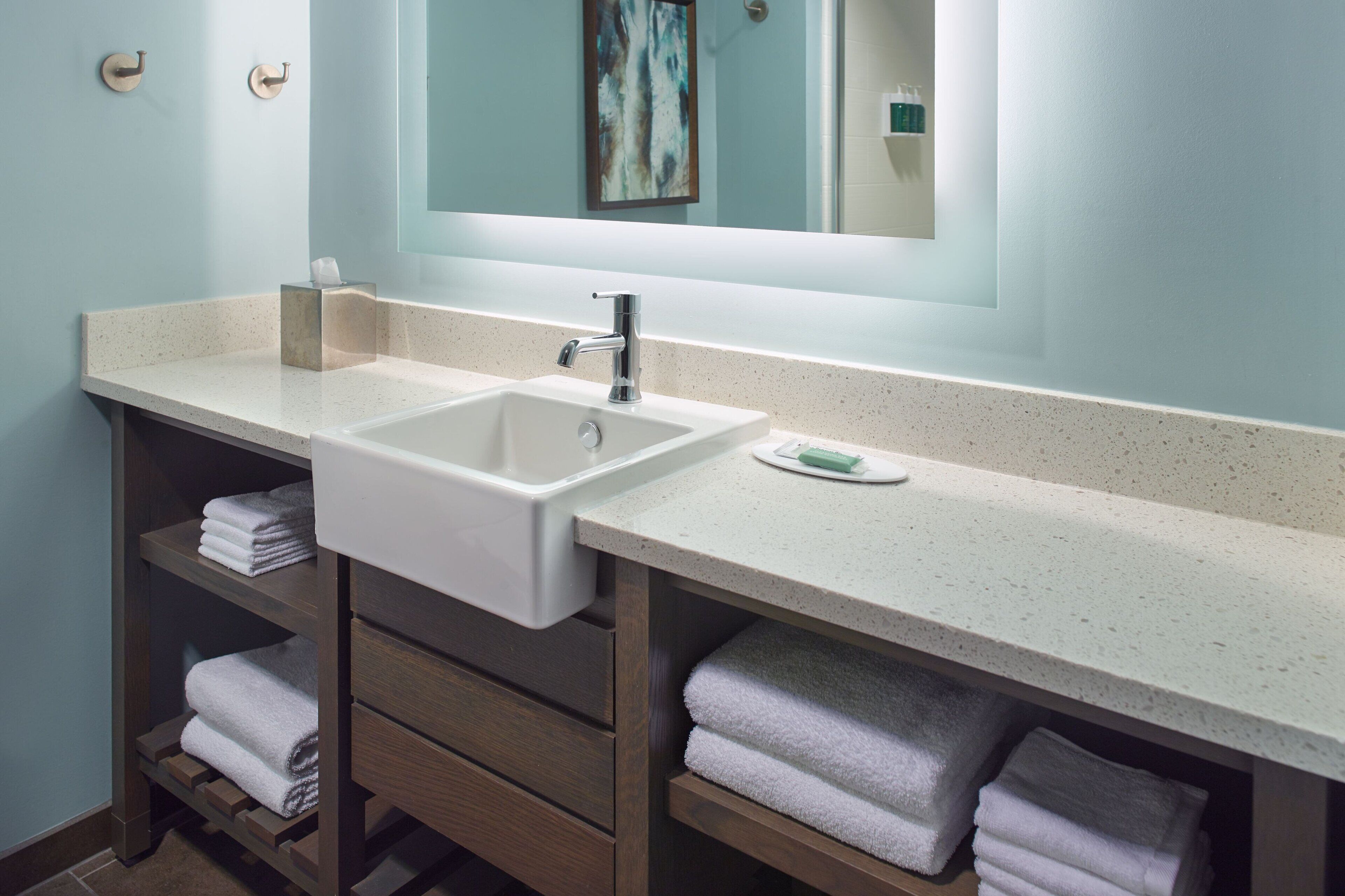 A modern bathroom with a double sink, wooden vanity, and a large mirror.