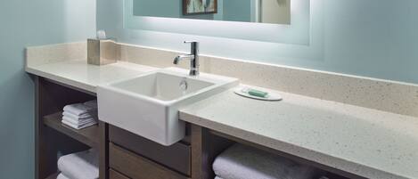 Un baño moderno con lavamanos doble, tocador de madera y un espejo grande.