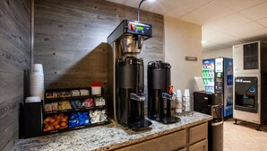 A coffee station with a coffee machine, a vending machine, and a water dispenser.