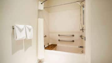 Un baño con bañera, ducha y un perchero con dos toallas.