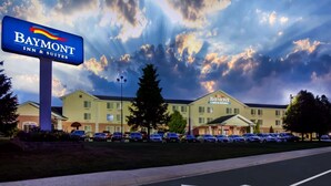 A Baymont Inn & Suites building with a parking lot and a signboard.