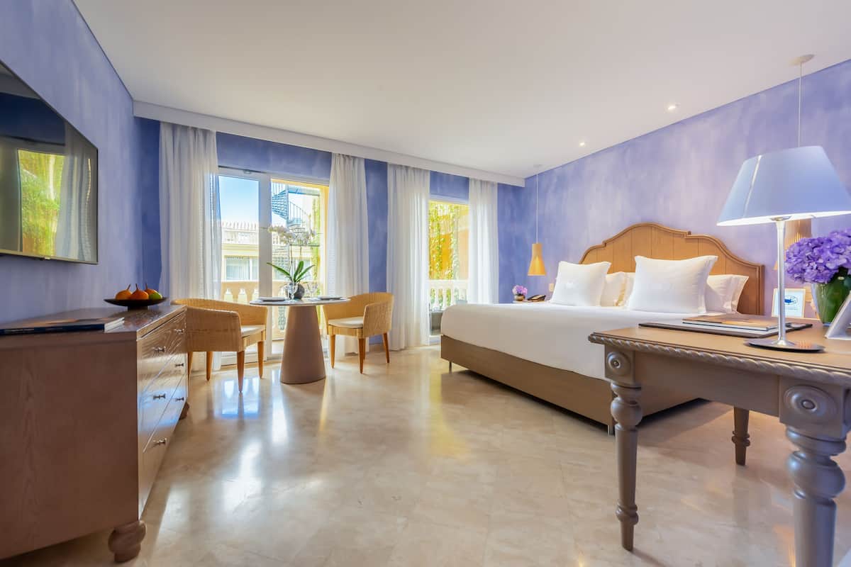 Een hotelkamer met een groot bed, een bureau, een stoel en uitzicht.