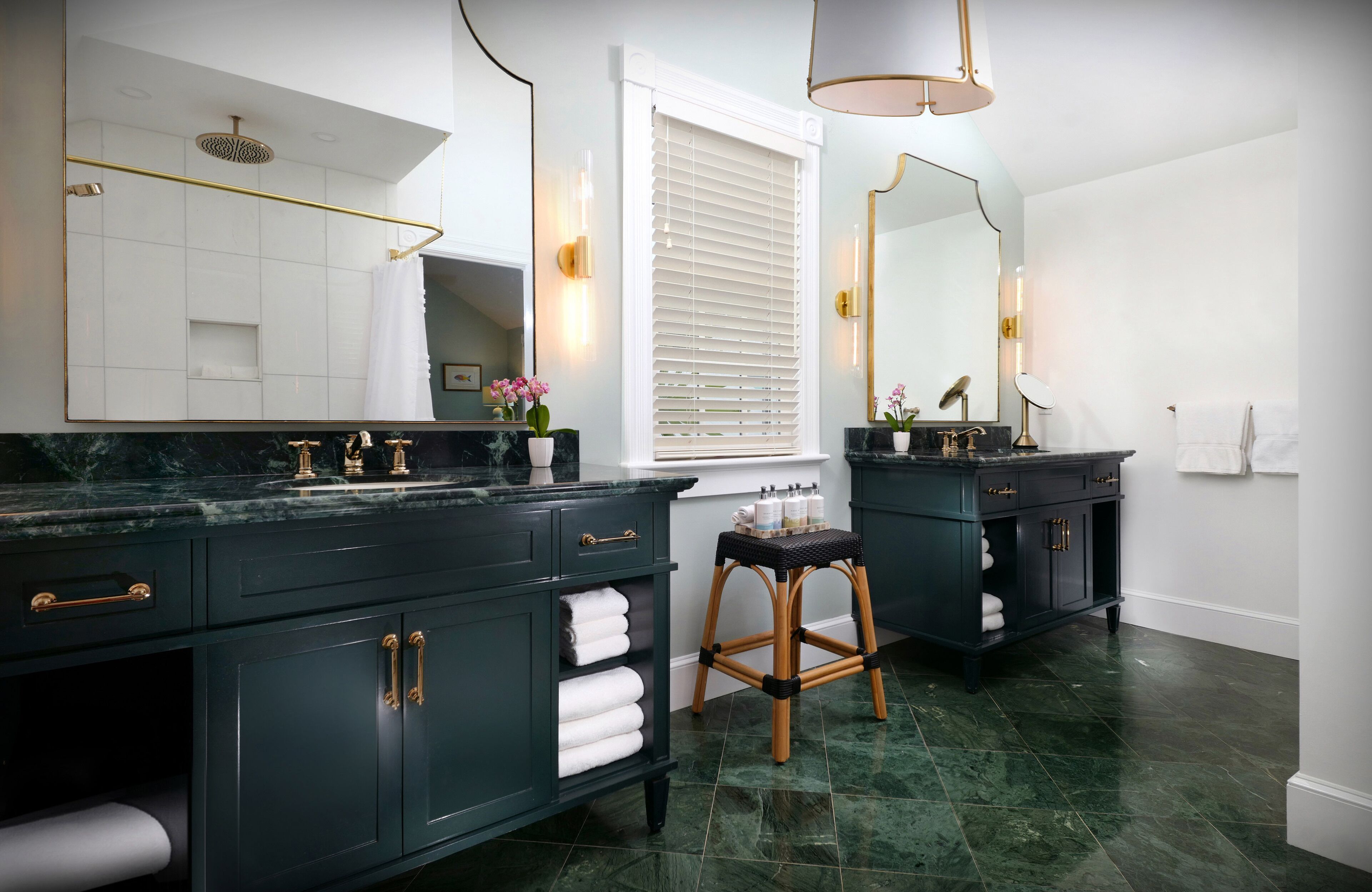 Un baño moderno con muebles oscuros, un espejo grande y una zona de ducha.