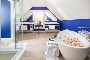 A modern bathroom with a freestanding bathtub, a glass shower enclosure, and a vanity with a mirror.