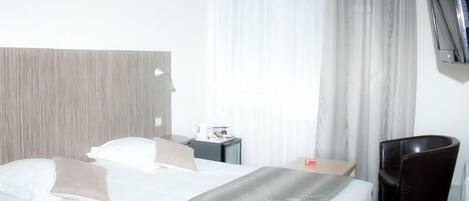 Chambre Confort double ou avec lits jumeaux | Bureau, rideaux d’obscurcissement, fer et planche à repasser