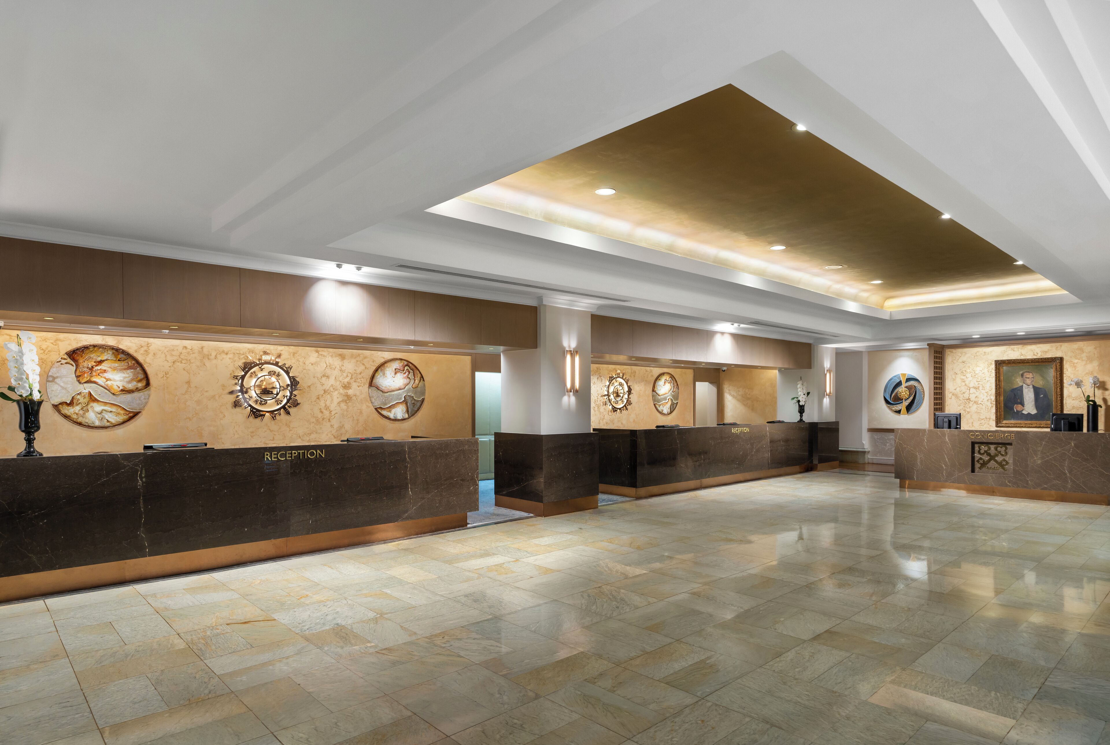 A spacious lobby with reception desks, a high ceiling, and a polished floor.