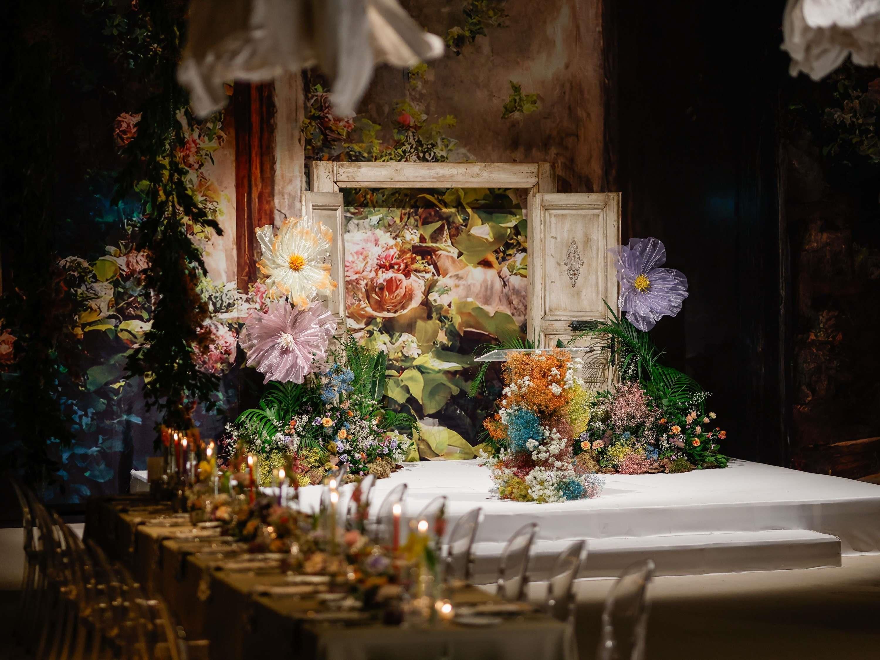 A long table set for a formal event with floral centerpieces and candles.