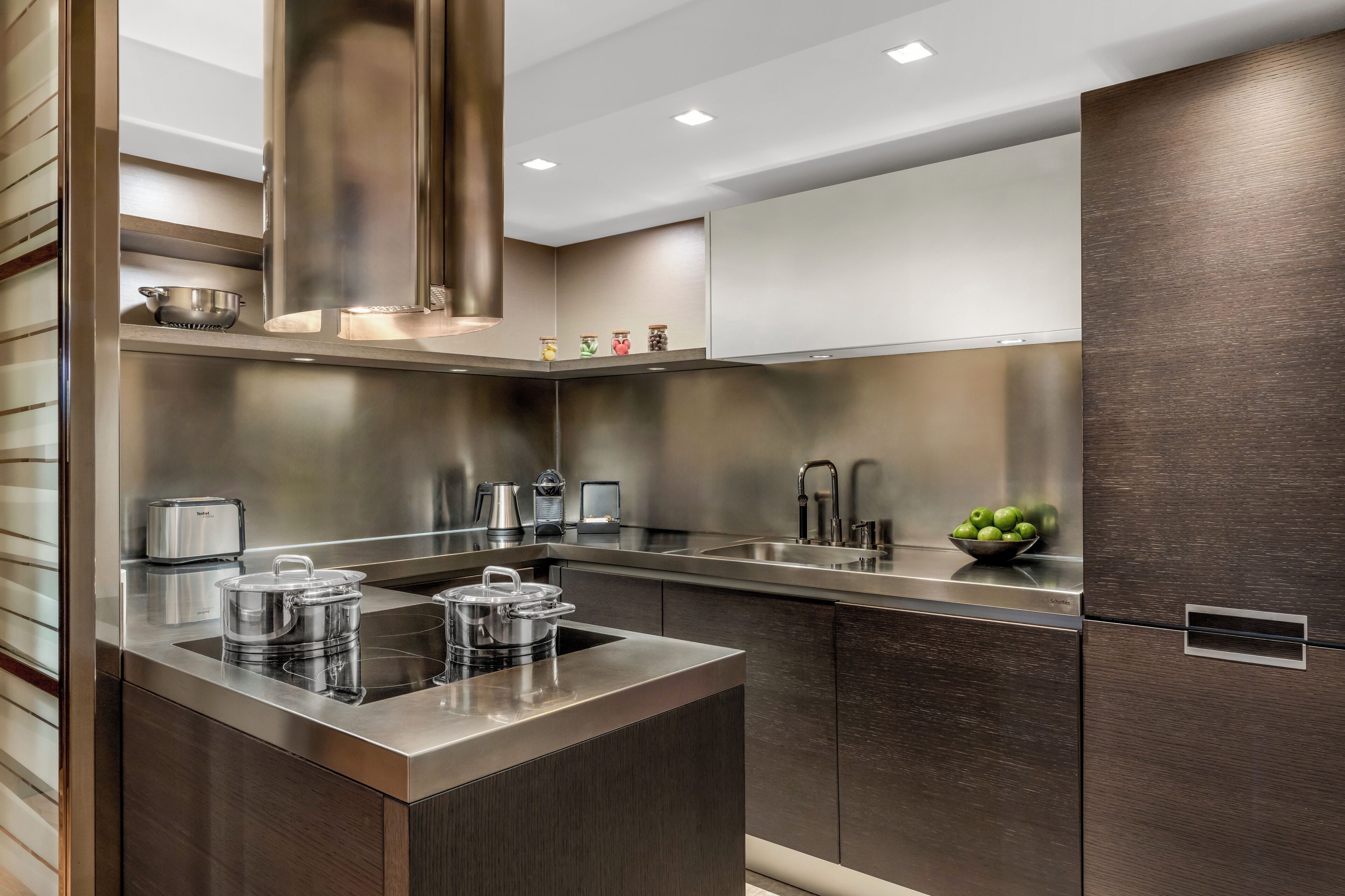 A modern kitchen with stainless steel appliances, a central island, and a dark wood finish on the cabinets.