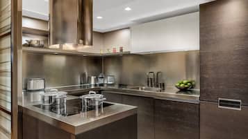 Una cocina moderna con electrodomésticos de acero inoxidable, una isla central y acabados oscuros de madera en los armarios.