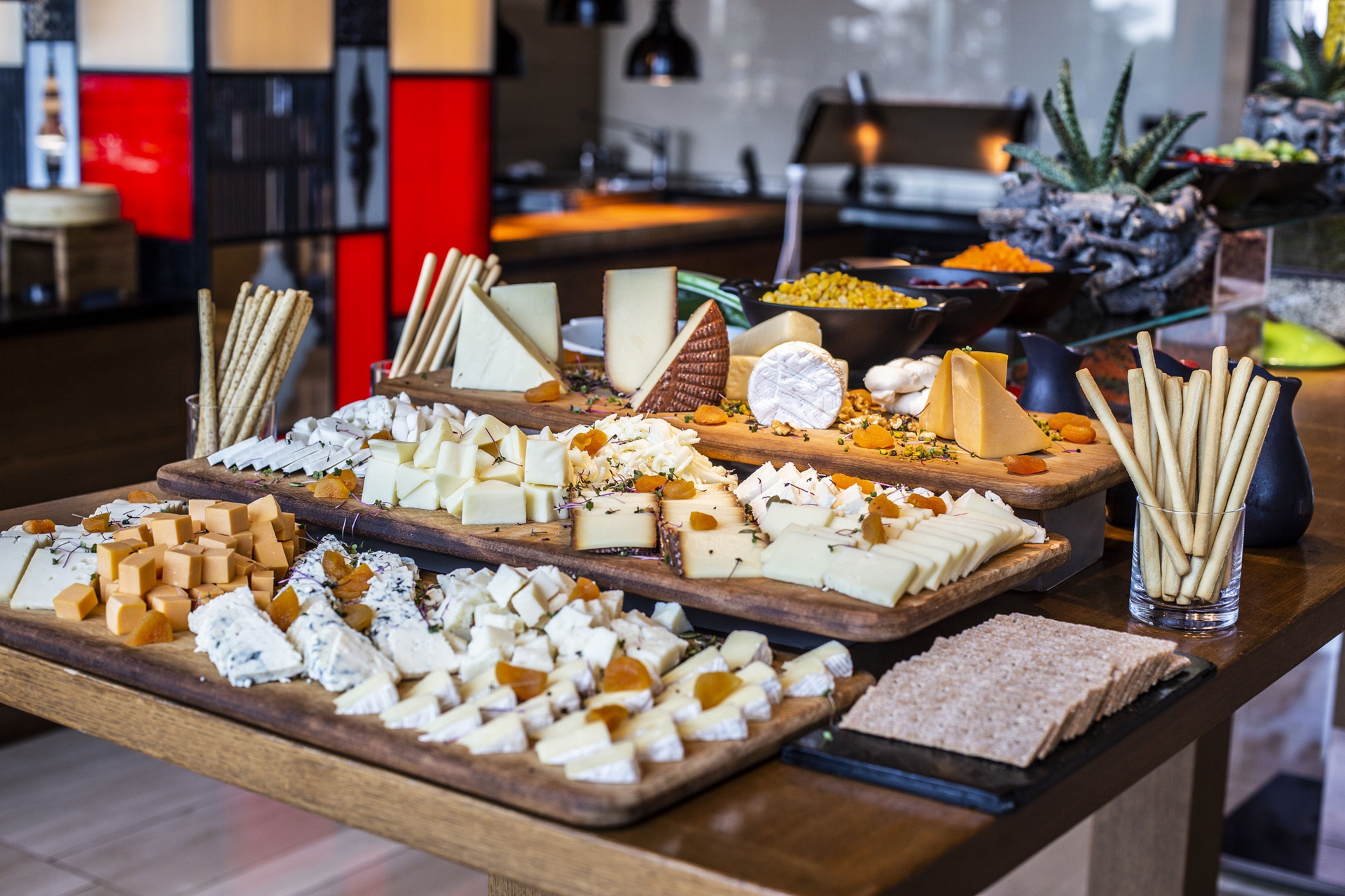 A cheese and cracker board with various cheeses and crackers.