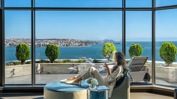 A spacious room with large windows offering a view of the sea and a distant cityscape. - Swissotel The Bosphorus Istanbul (Istanbul)
