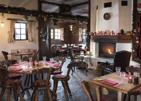 Un restaurante acogedor con muebles de madera, chimenea y decoración festiva.