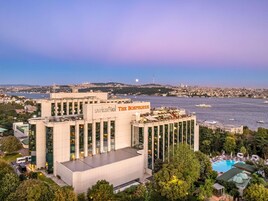 A modern hotel with a rooftop pool and a view of the city and water.