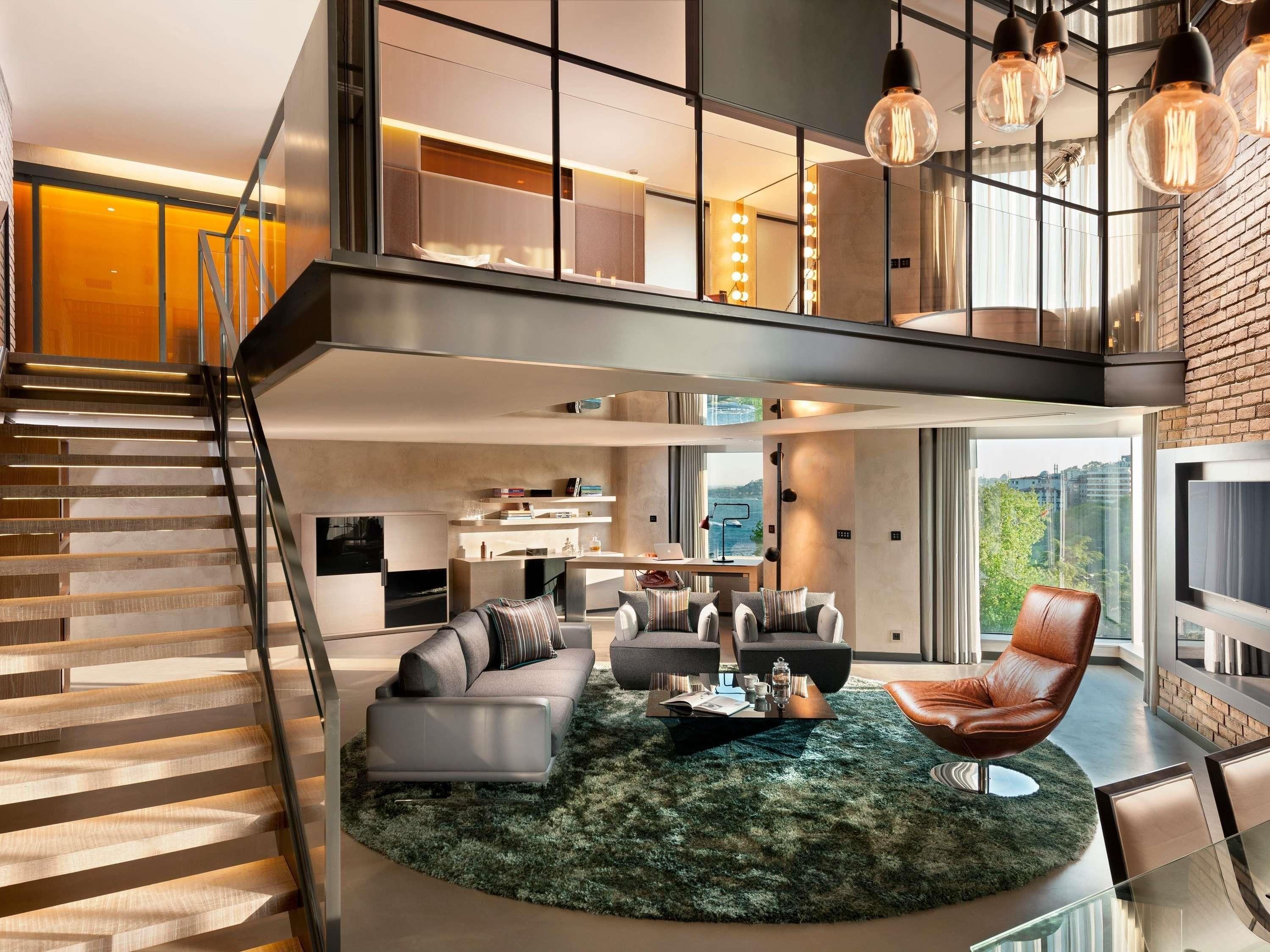Un espace de vie moderne comprenant un escalier, un coin salon avec une table basse et un téléviseur.