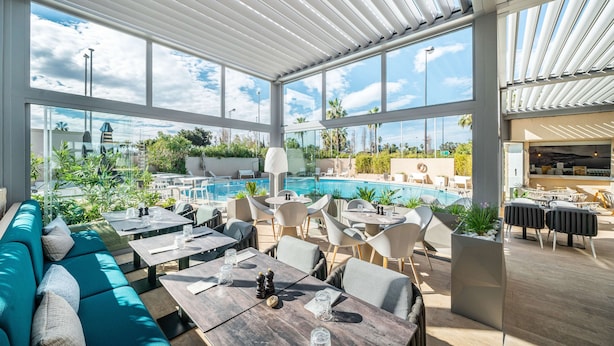A rooftop bar with outdoor seating, a pool, and a view of the surrounding landscape. - Radisson Hotel Nice Airport (Nice)