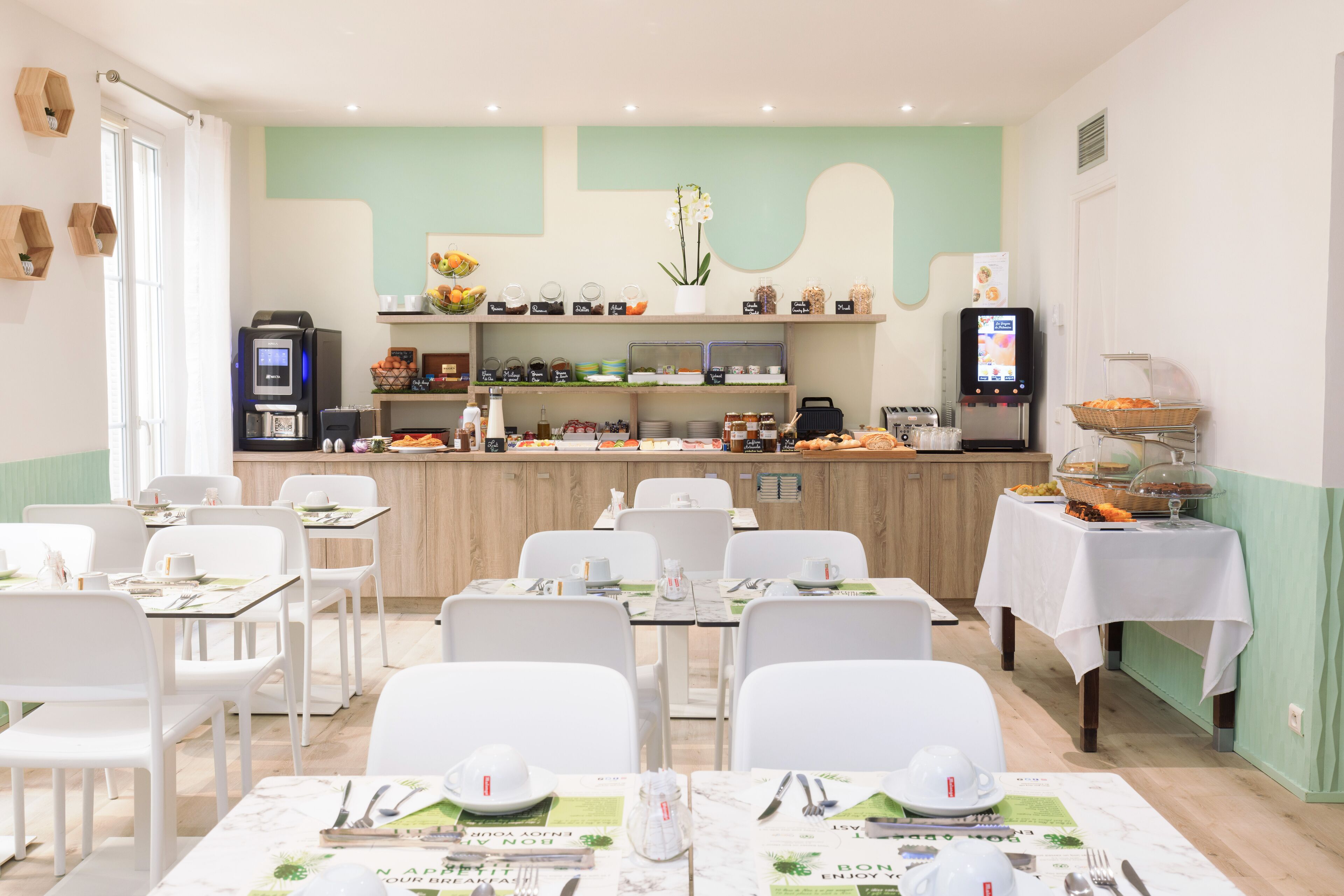 A dining area with white chairs and tables, a buffet counter with various food items, and a coffee machine.