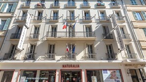 Un edificio con balcones, un letrero que dice "Hotel Florence" y una tienda llamada "Naturalia".