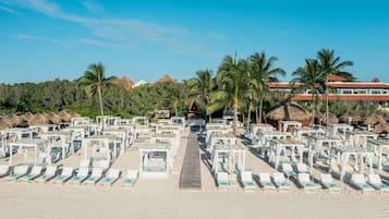 På stranden, hvit sand, solsenger og parasoller