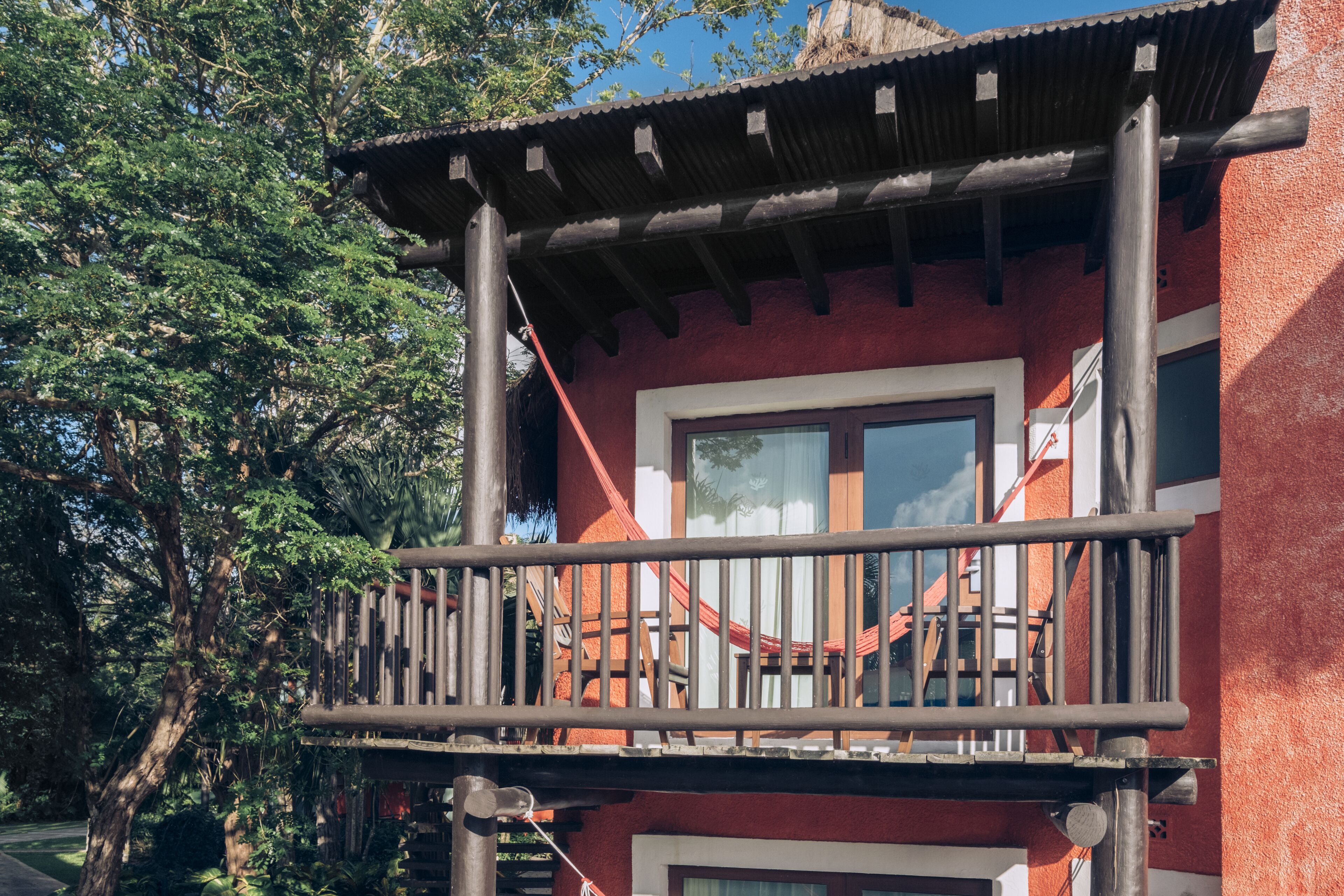 A two-story building with a balcony, a window, and a door.