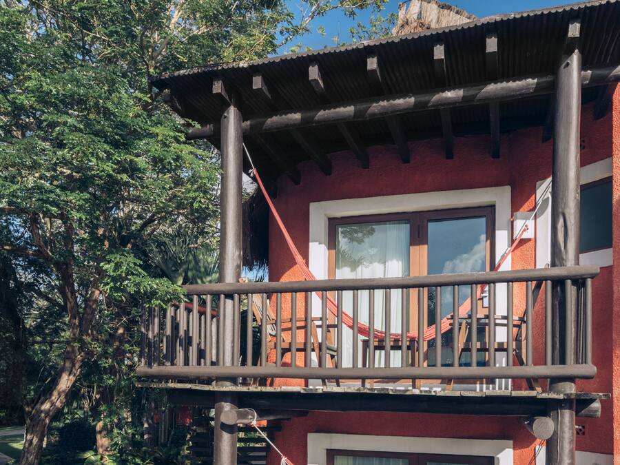 A two-story building with a balcony, a window, and a door.