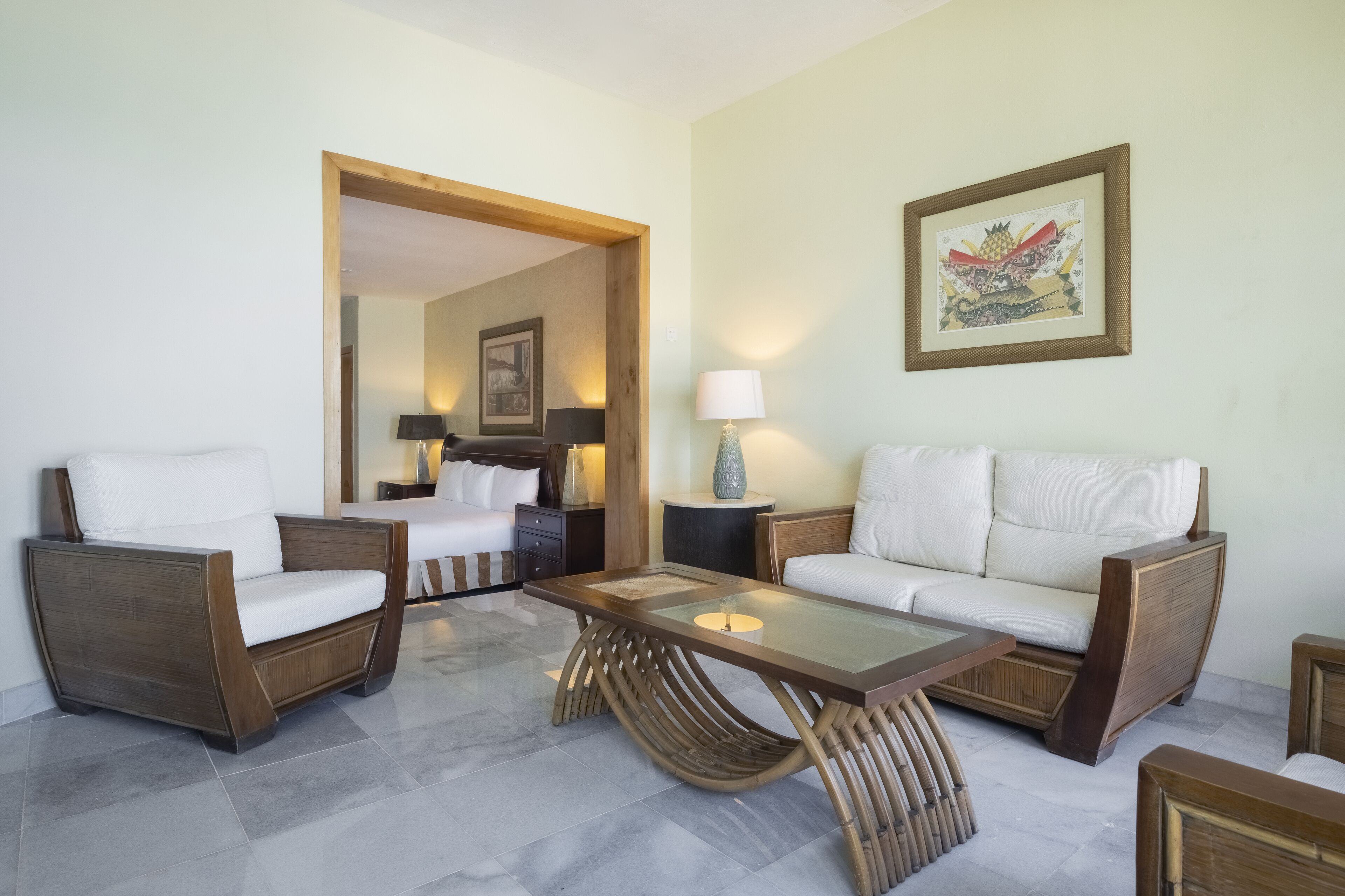 Uma sala de estar moderna com um sofá, poltronas e uma mesa de centro de vidro.