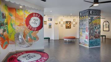 A modern interior with a colorful mural, a bus stop sign, and a ceiling fan.