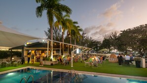 Zona de piscina exterior con bar y asientos.