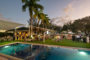 An outdoor pool area with a bar and seating. - The Rockley by Ocean Hotels (Rockley)