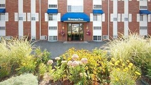 Un hôtel à la façade en briques, doté d’auvents bleus et d  ’une enseigne indiquant « Riverview Inn ».