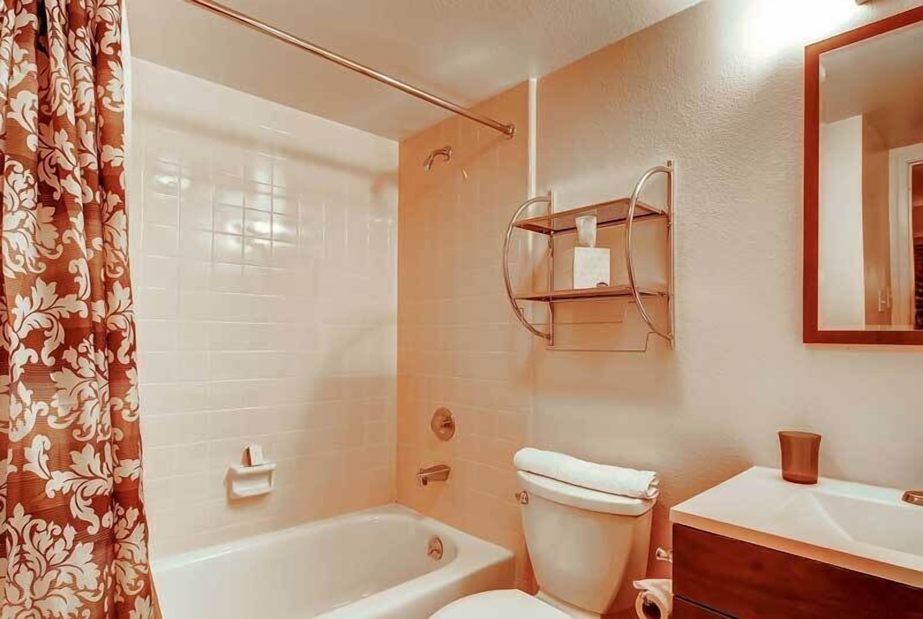 Une salle de bain avec une baignoire, des toilettes et un lavabo avec un miroir.