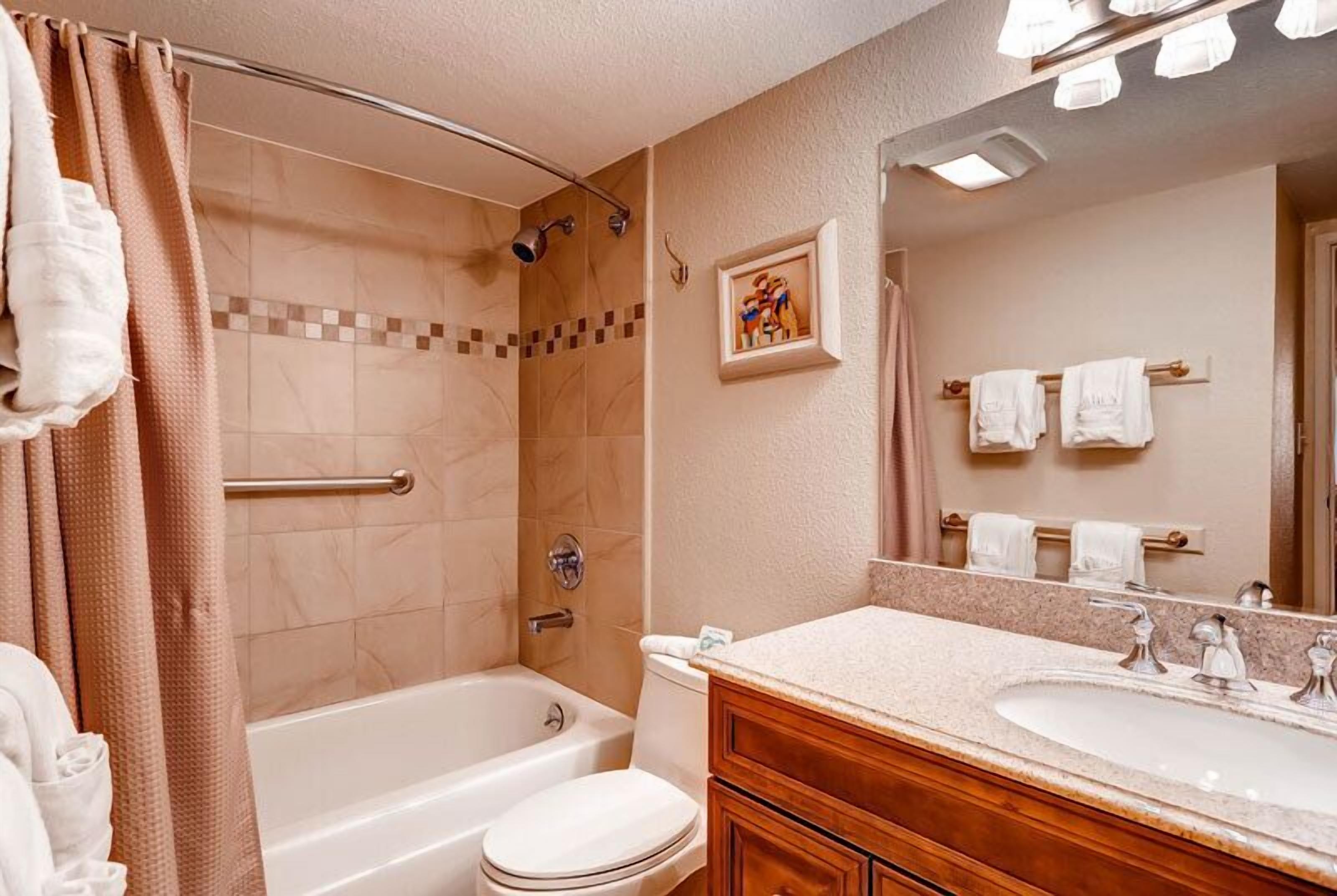 Un baño con bañera, inodoro y lavamanos.